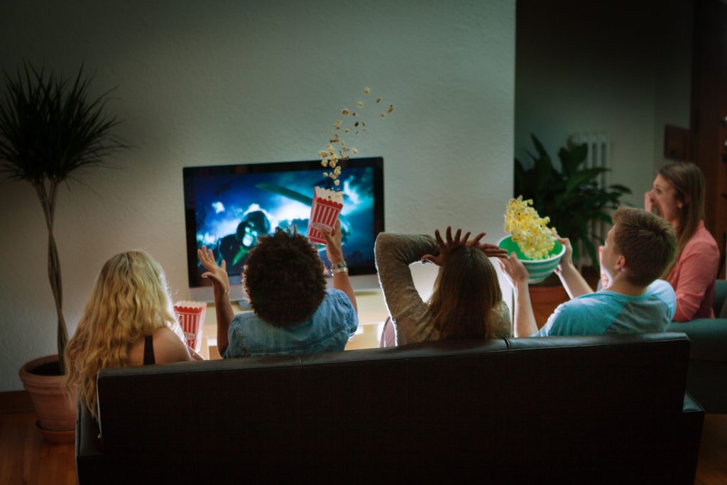 Group of Friends Watching Halloween Scary Movie Together at Home